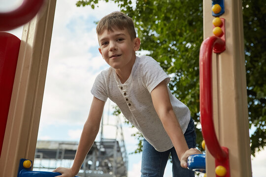 little caucasian kid playing at playground. skinny boy having fun outdoors. childhood concept, outdoor activity, sport at school