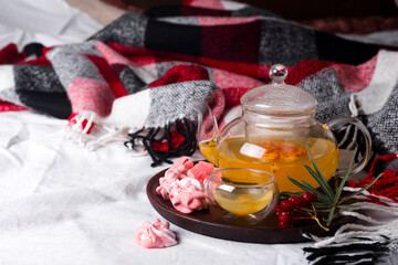 tray with honey and a cup of hot tea with pink meringues in the bed,