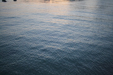 The calm waves of the sunset winter sea.

