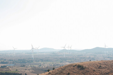 Wind power generation and scenery from the parasitic cone of Jeju Island in the winter.

