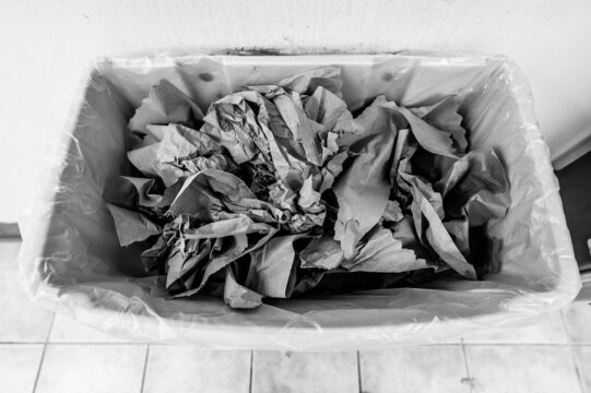 Crumpled brown paper towels in a trash can after being used to dry hands