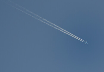 Avion et sa trainée de condensation dans un ciel bleu