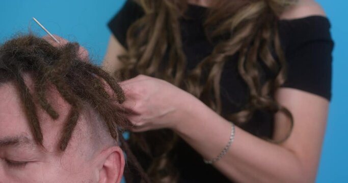 The master corrects natural dreadlocks for the client. Close-up. Long process.