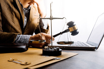 Business and lawyers discussing contract papers with brass scale on desk in office. Law, legal services, advice, justice and law concept picture with film grain effect
