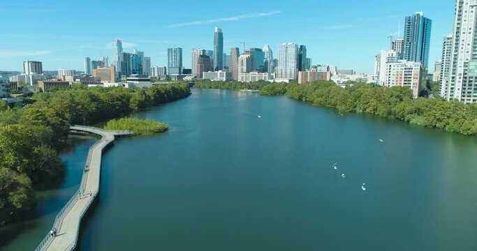 Austin Texas Colorado River and Lady Bird Lake with Boardwalk and Downtown Skyline with Paddleboards Next to Ann and Roy Butler Hike and Bike Trail (Aerial Drone View in 4k)