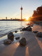 Sunrise on the banks of the river Rhine in Dusseldorf. The skyline of the city with the Rheinturm tower.