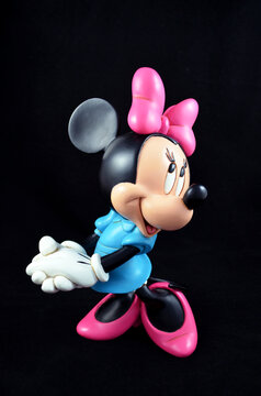 Studio image of a Minnie Mouse figurine with a black isolated background.