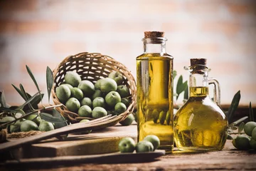 Fototapeten Olivenöl mit frischen Oliven auf rustikalem Holz © Fabio Balbi