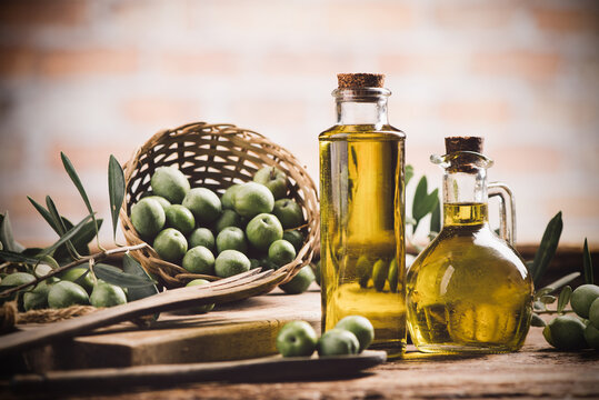Olive oil with fresh olives on rustic wood