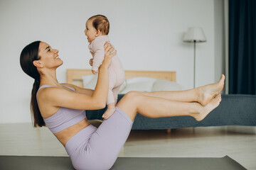 Mother with her baby daughter practice yoga at home