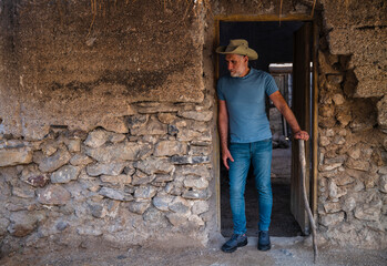 Fototapeta na wymiar Adult man in cowboy hat and jean in a rural area