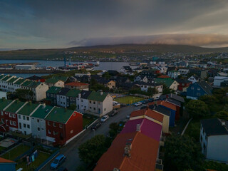 Naklejka premium Beautiful aerial view of the City of Torshavn Capital of Faroe Islands- View of Cathedral, colorful buildings, marina, suburbs and Flag