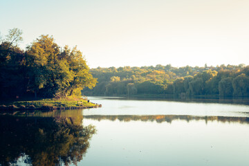 Naklejka na ściany i meble Trees reflecting in the water at the Malomvölgyi-tó in fall, Pécs, Hungary