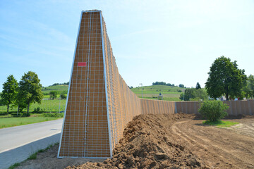 Errichtung/Aufbau einer Lärmschutzwand in zur Stabilisierung mit Jute-Geotextil ausgekleideter...