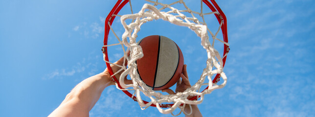 hand and basketball. dunk in basket. slam dunk in motion. professional player. © Olena