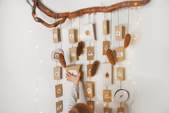 Little boy reaching for the box of advent calendar. Closeup.