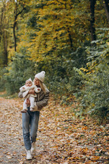 Fototapeta premium Woman with toddler child in autumn park