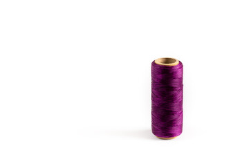 A coil of purple thread. Spool of colored threads on a white background. Waxed sewing thread for...
