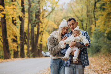 Fototapeta premium Young family with little daughter in autumn park