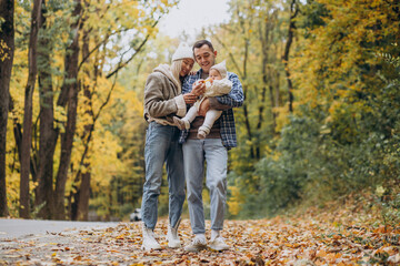 Young family with little daughter in autumn park