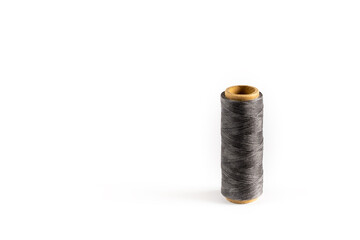 A coil of gray thread. Spool of colored threads on a white background. Waxed sewing thread for...