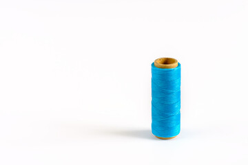 A coil of cyan thread. Spool of colored threads on a white background. Waxed sewing thread for leather crafts.
