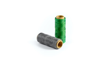 A skein of green and gray thread. Coils of colored threads on a white background. Waxed sewing thread for leather goods.