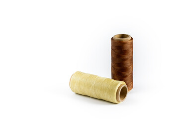 A skein of brown and beige thread. Coils of colored threads on a white background. Waxed sewing...