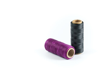 A skein of black and purple thread. Coils of colored threads on a white background. Waxed sewing...