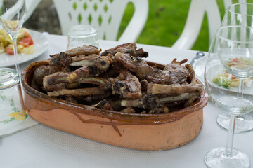 Clay bowl full of grilled lambs chops, ready to eat
