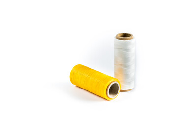 A skein of yellow and white thread. Coils of colored threads on a white background. Waxed sewing thread for leather goods.
