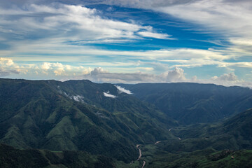 mountain valley with dramatic sunset sky and low clouds at evening