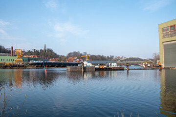 Fototapeta na wymiar Gelber Kran, Binnenschiff und Brücke im Hafen von Lauenburg