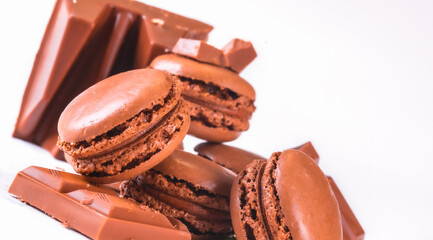 Macaroons with Sweet Chocolate and Coffee Beans on White Wooden Table