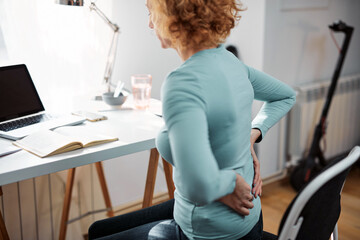 Woman with hip, back, spine spasm, cramp and pain, working from home troubles and issues.