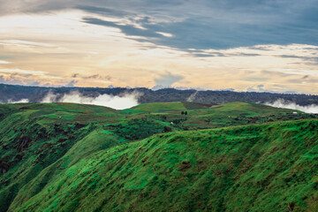 Fototapeta premium mountain valley with dramatic sunset sky and low clouds at evening