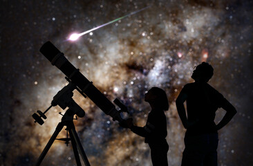 Silhouettes of father, daughter and astronomical telescope under starry skies. © astrosystem