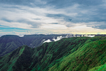 Obraz premium mountain valley with dramatic sunset sky and low clouds at evening