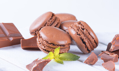 Macaroons with Sweet Chocolate and Coffee Beans on White Wooden Table