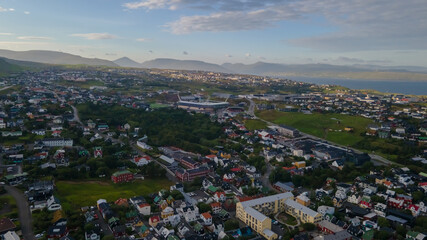 Beautiful aerial view of the City of Torshavn Capital of Faroe Islands- View of Cathedral, colorful buildings, marina, suburbs and Flag