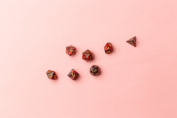 Stone gaming dice different shapes on pastel pink background. Top view. Flat lay. Copy space. Game of chance concept. Close-up. Pastel colors