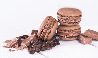 Macaroons with Sweet Chocolate and Coffee Beans on White Wooden Table