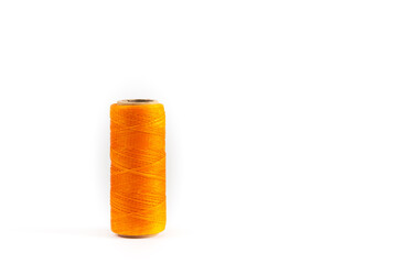 A coil of orange thread. Spool of colored threads on a white background. Waxed sewing thread for...