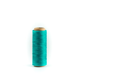 A coil of aqua thread. Spool of colored threads on a white background. Waxed sewing thread for...