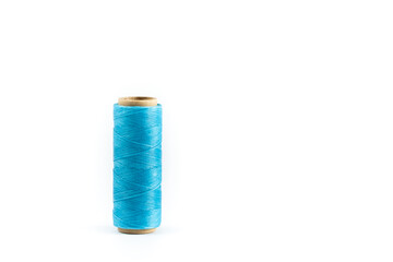 A coil of cyan thread. Spool of colored threads on a white background. Waxed sewing thread for leather crafts.