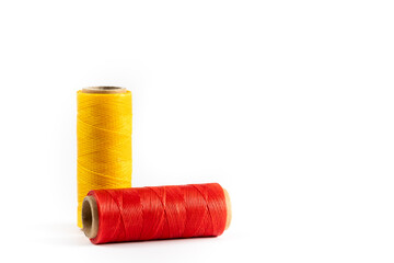 A skein of yellow and red thread. Coils of colored threads on a white background. Waxed sewing...
