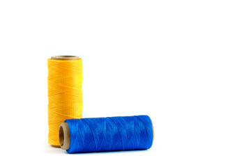 A skein of yellow and blue thread. Coils of colored threads on a white background. Waxed sewing thread for leather goods.