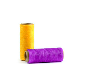 A skein of yellow and purple thread. Coils of colored threads on a white background. Waxed sewing...