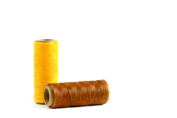 A skein of yellow and brown thread. Coils of colored threads on a white background. Waxed sewing...
