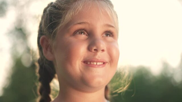 portrait of a little girl in nature smiling in the park. happy family kid dream concept. daughter with chubby cheeks cheerful smiling in the park. little girl close-up. family happy childhood concept